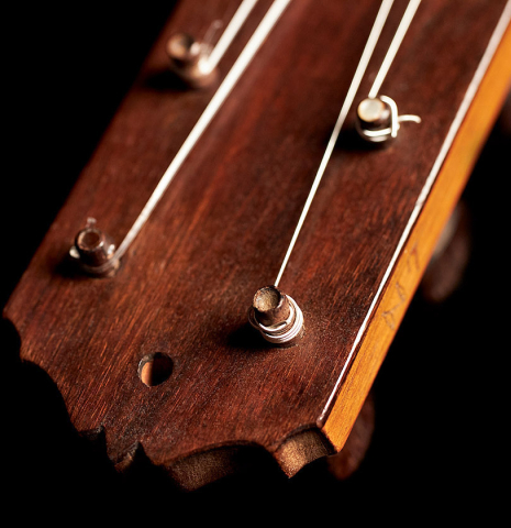 The headstock and tuning pegs of a 1916 Viuda de Manuel Ramirez flamenco guitar made with spruce and cypress and pegs