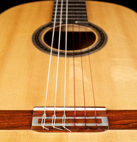 The soundboard and bridge of a 2003 Antonio Raya Pardo flamenco guitar made with spruce top and cypress back and sides