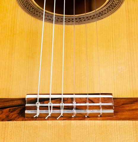 The bridge, tie-block and saddle of a 1991 Antonio Raya Pardo flamenco guitar made of spruce and cypress