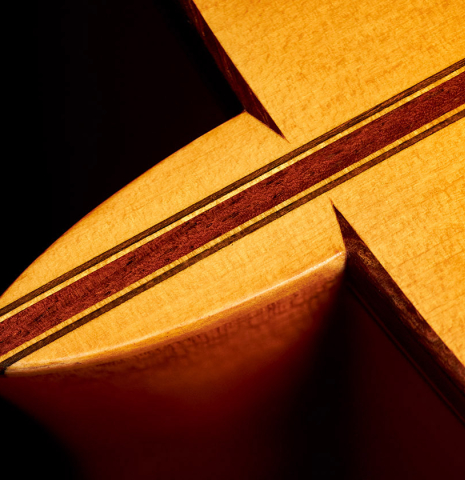A close-up of the heel of a 1974 Manuel Reyes flamenco guitar made of spruce and cypress with traditional pegs