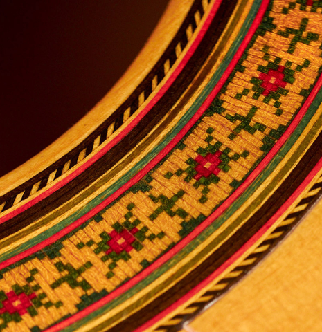 A close-up of the rosette of a 1974 Manuel Reyes flamenco guitar made of spruce and cypress with traditional pegs