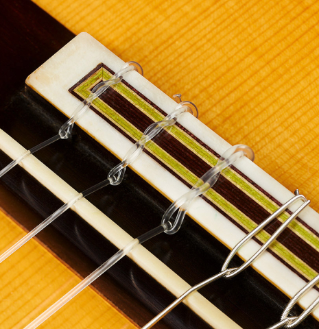 The bridge, tie-block and saddle of a 1997 Manuel Reyes flamenco guitar made of spruce and cypress