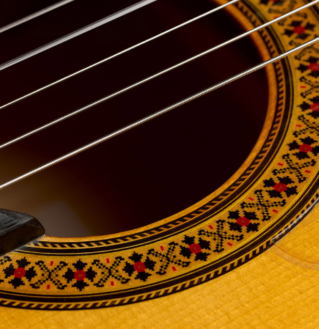 The soundboard and rosette detail of a 1992 Manuel Reyes flamenco blanca guitar made of spruce and cypress