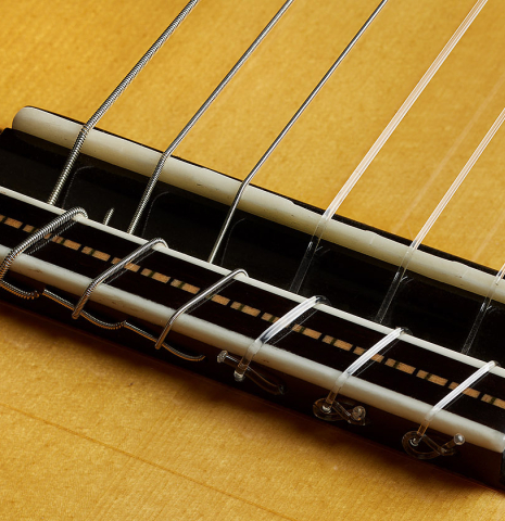 The bridge, tie-block and saddle of a 2025 Rojas &amp; Sanzol flamenco blanca guitar made of spruce and cypress