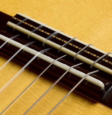 The bridge, tie-block and saddle of a 2025 Rojas &amp; Sanzol flamenco guitar made of spruce and cypress