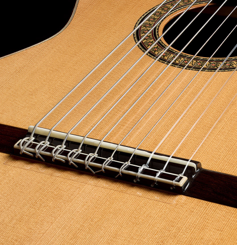 The bridge, tie-block and saddle of a 2025 Rojas &amp; Sanzol "10-string" classical guitar made of cedar and Indian rosewood