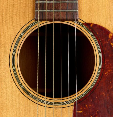 The soundhole of a 1951 Martin D-18 steel-string guitar made of spruce and mahogany