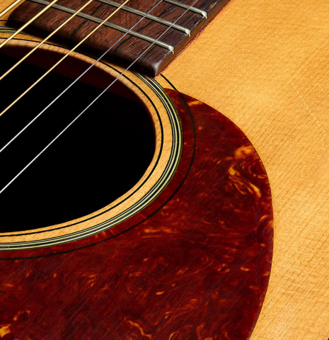 The top and pick guard of a 1951 Martin D-18 steel-string guitar made of spruce and mahogany