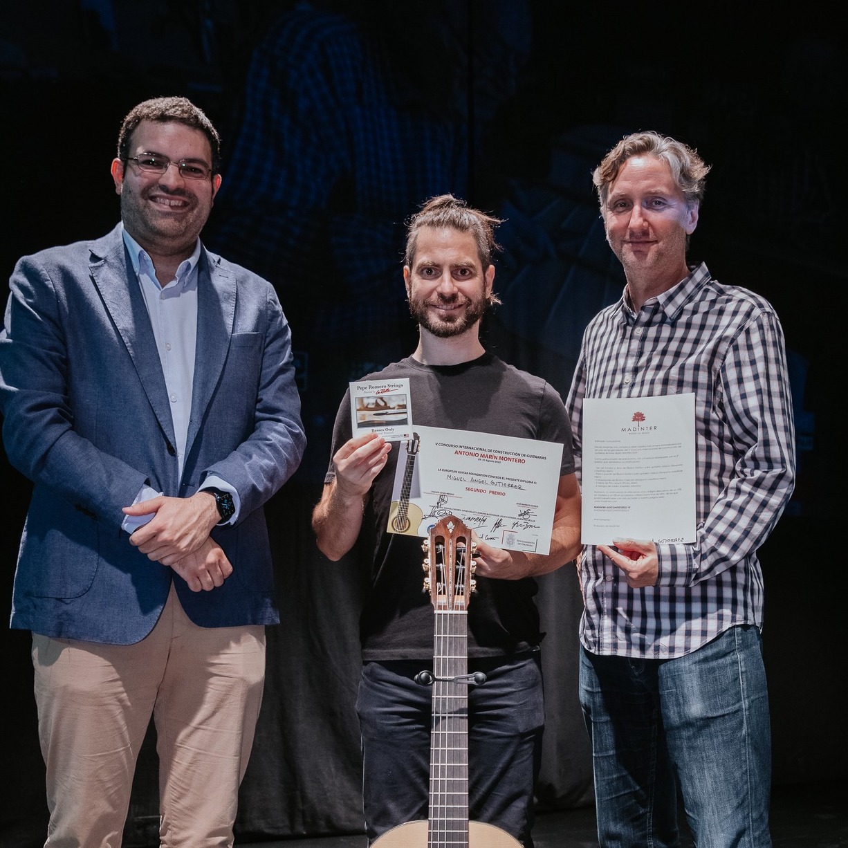 Vicente Coves, Miguel Angel Gutiérrez holding his second-prize diploma, and David Collett at the 2022 Antonio Marín Montero Competition in Granada
