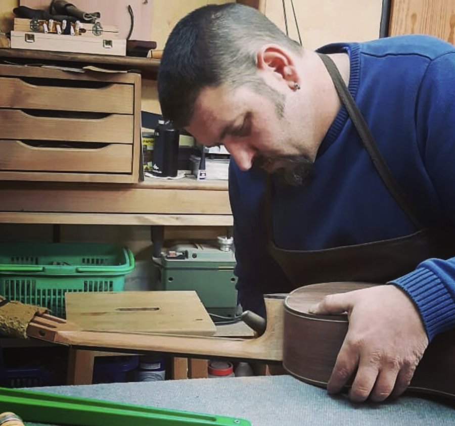 Marco Tejeda working on a classical guitar at his workbench in the Pérez family workshop in Madrid